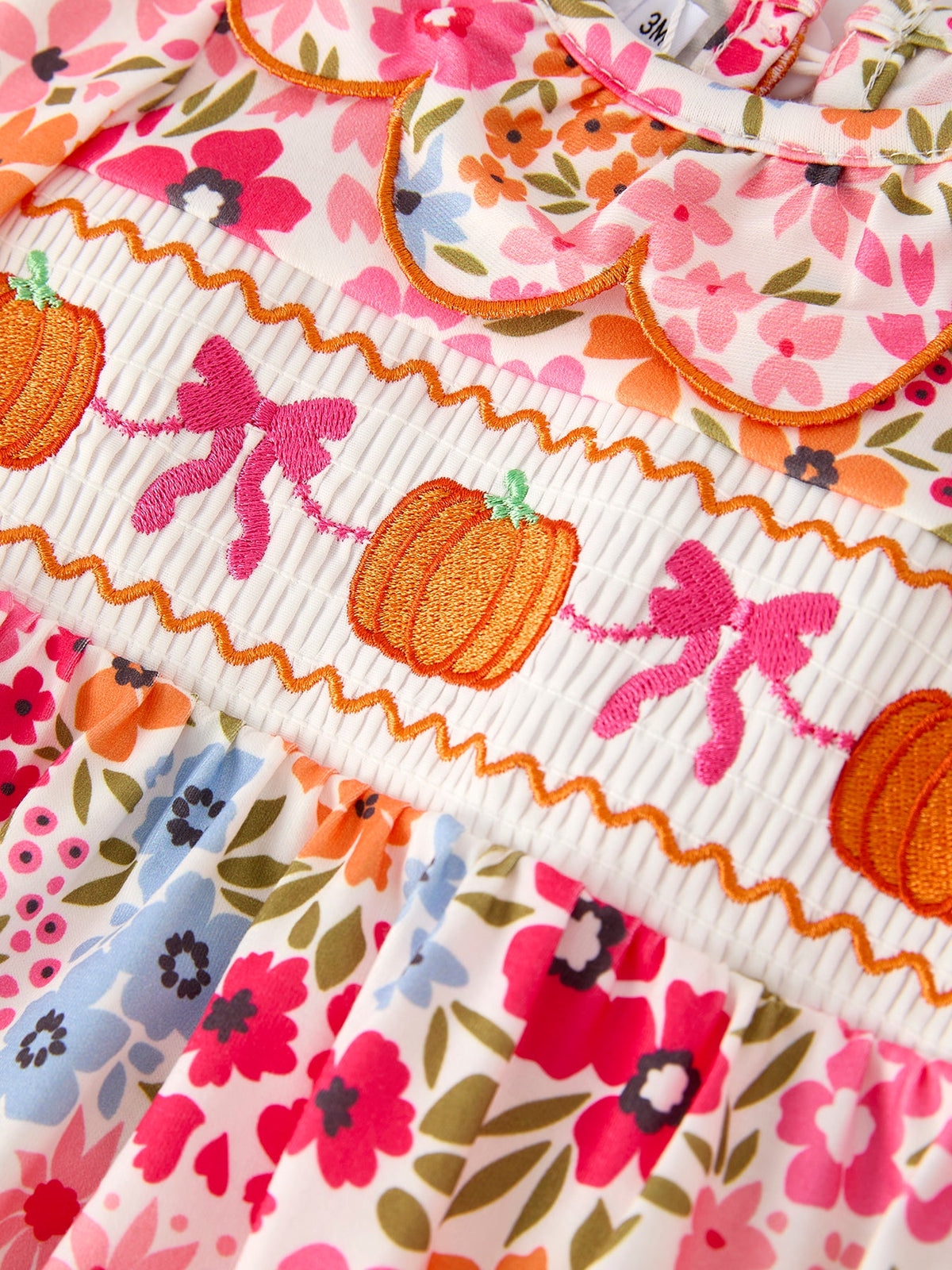 Fall pumpkin bow smock romper for baby girl with embroidered pumpkins on floral print fabric