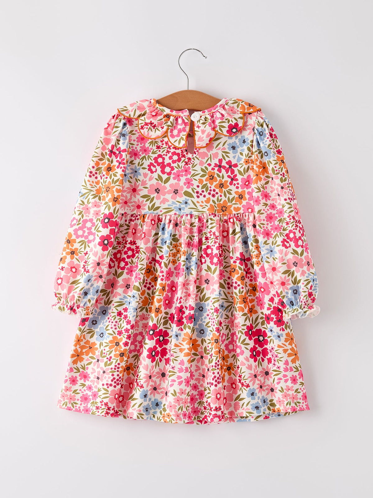 Fall floral smock dress on hanger with vibrant blossoms, long sleeves and gathered waist.