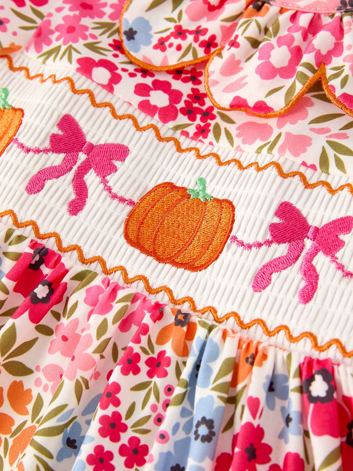 Pumpkin bow embroidery on smocked dress with orange piping and floral print