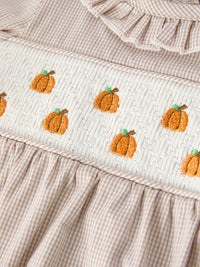 Fall pumpkin-embroidered smocked plaid baby girl romper with ruffle trim.