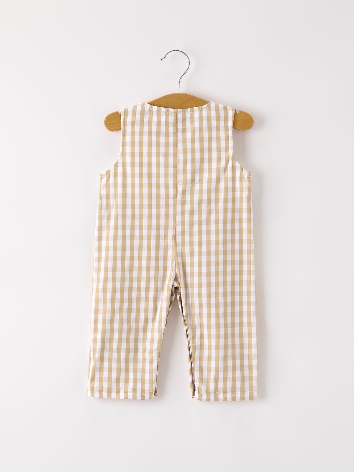 Back view of apricot plaid baby boy romper with smocking and chick embroidery hanging on a wooden hanger.