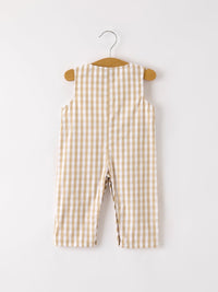 Back view of apricot plaid baby boy romper with smocking and chick embroidery hanging on a wooden hanger.