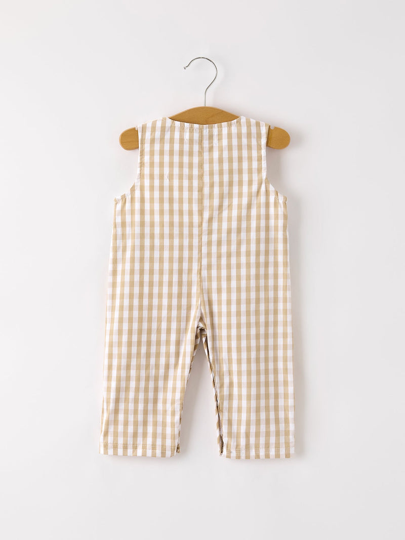 Back view of apricot plaid baby boy romper with smocking and chick embroidery hanging on a wooden hanger.