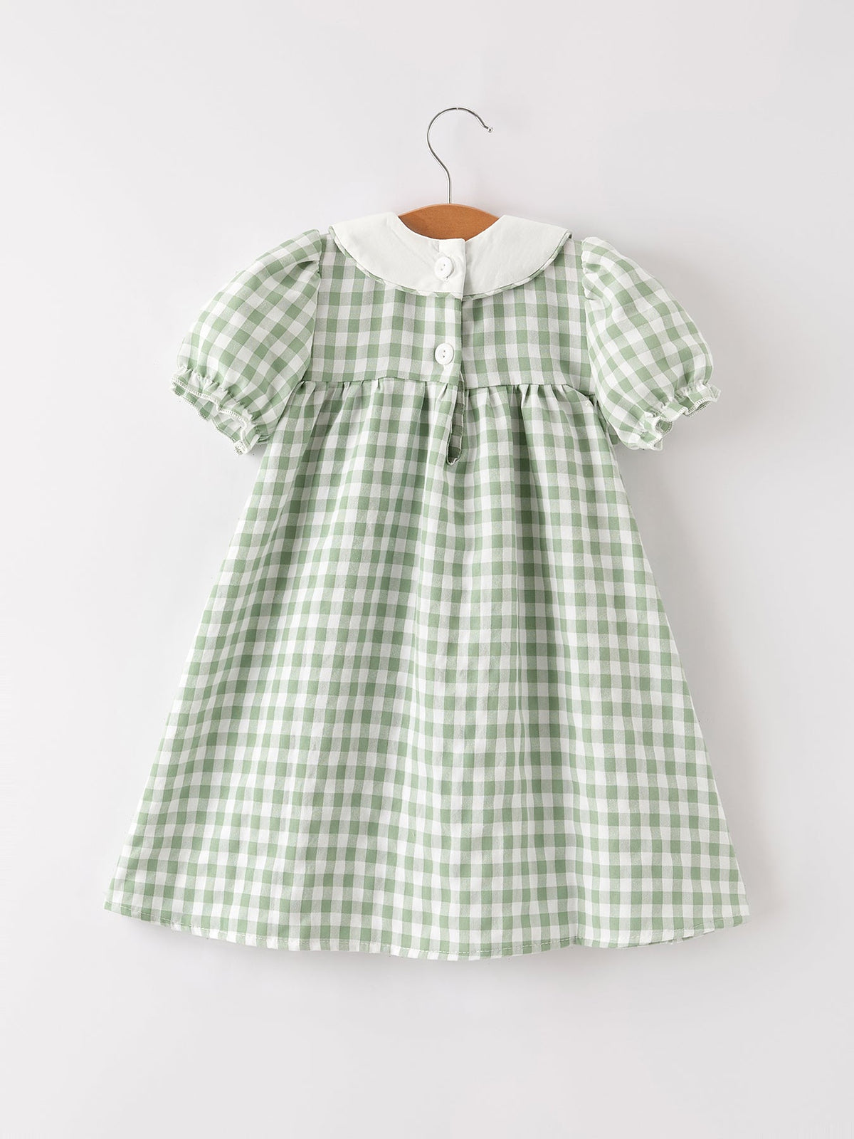Green plaid dress for girls with white collar and puff sleeves on a hanger.