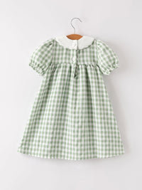 Green plaid dress for girls with white collar and puff sleeves on a hanger.
