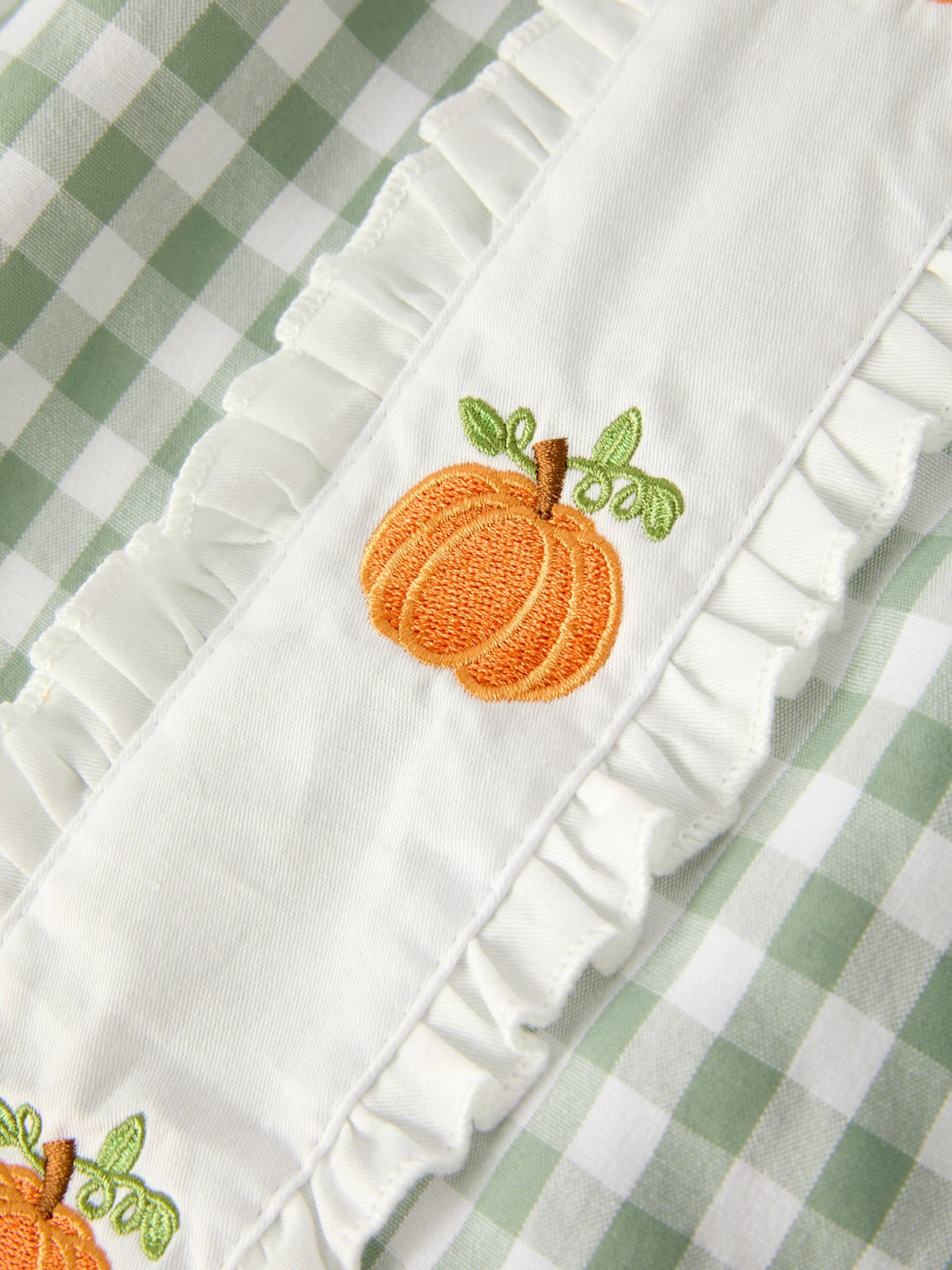 Green plaid fall dress for girls with pumpkin applique and white ruffled trim.