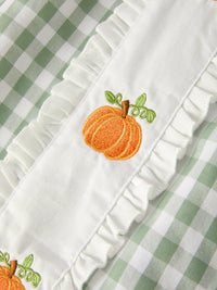 Green plaid fall dress for girls with pumpkin applique and white ruffled trim.