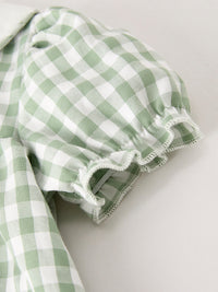 Close-up of green and white gingham plaid fabric with a scalloped ruffle edge.