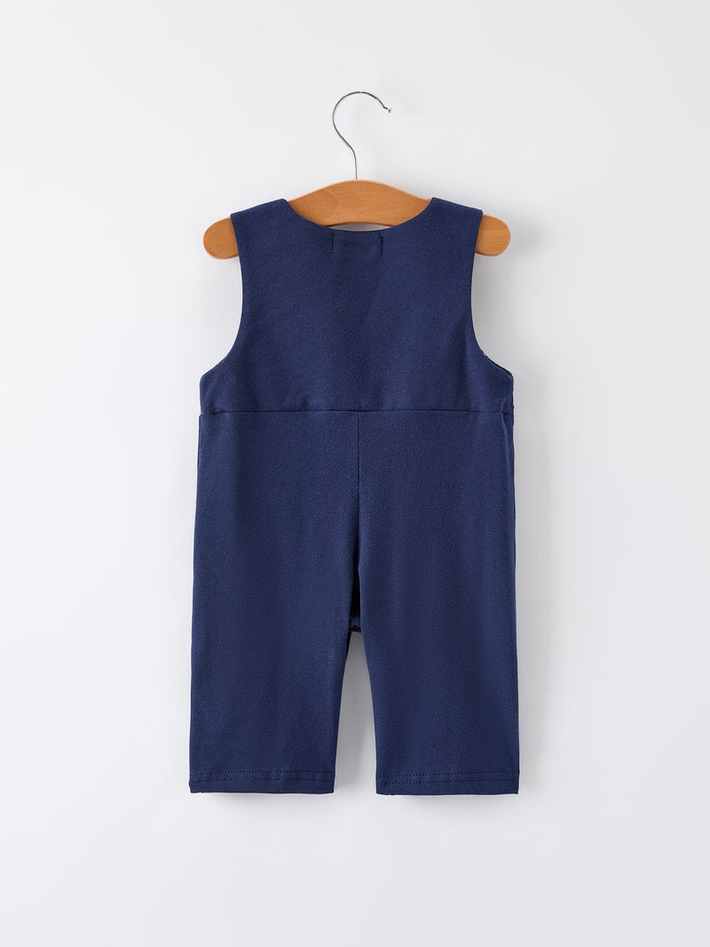 Back view of navy baby boys holiday romper on wooden hanger featuring Santa sleigh design for festive celebrations.