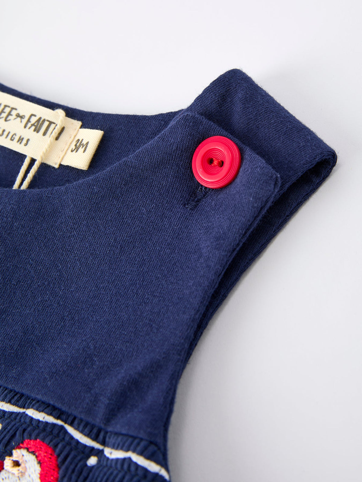 Navy baby boy romper shoulder with red button and label for Christmas Santa sleigh outfit.