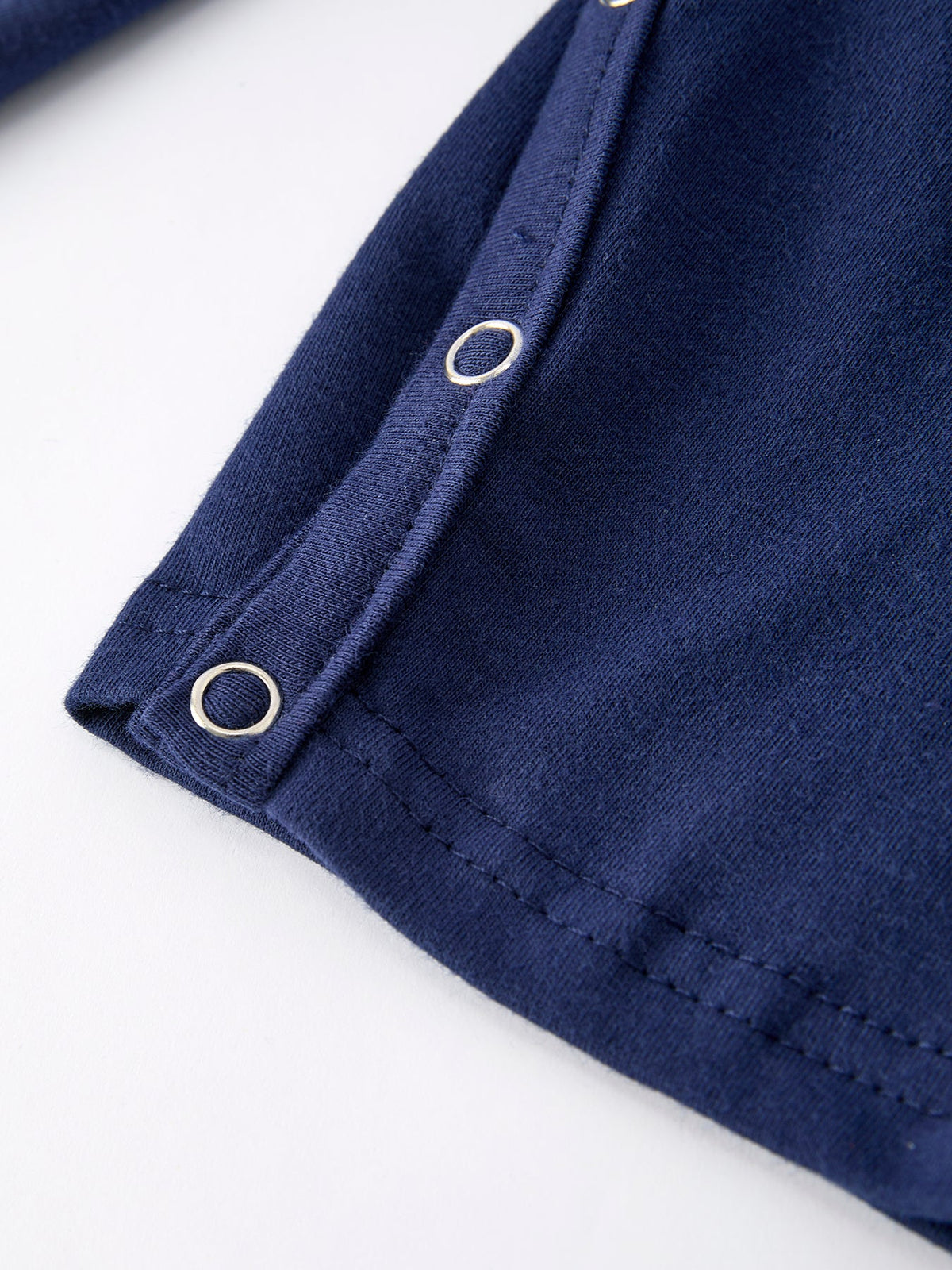 Navy baby romper leg detail showing silver snap buttons and soft knit fabric for easy dressing.