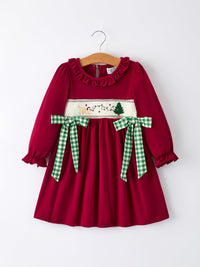 Red girls Christmas dress with festive smocking, green plaid bows, and embroidered tree and dog on a hanger.