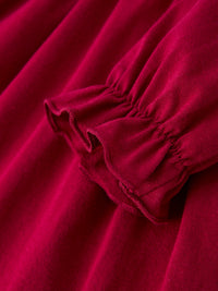 Red Christmas girls dress featuring delicate smocking and a ruffled elastic cuff detail on the sleeve.