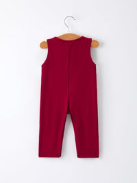 Back view of a sleeveless deep red baby boys jon jon romper hanging on a wooden hanger against a white background.