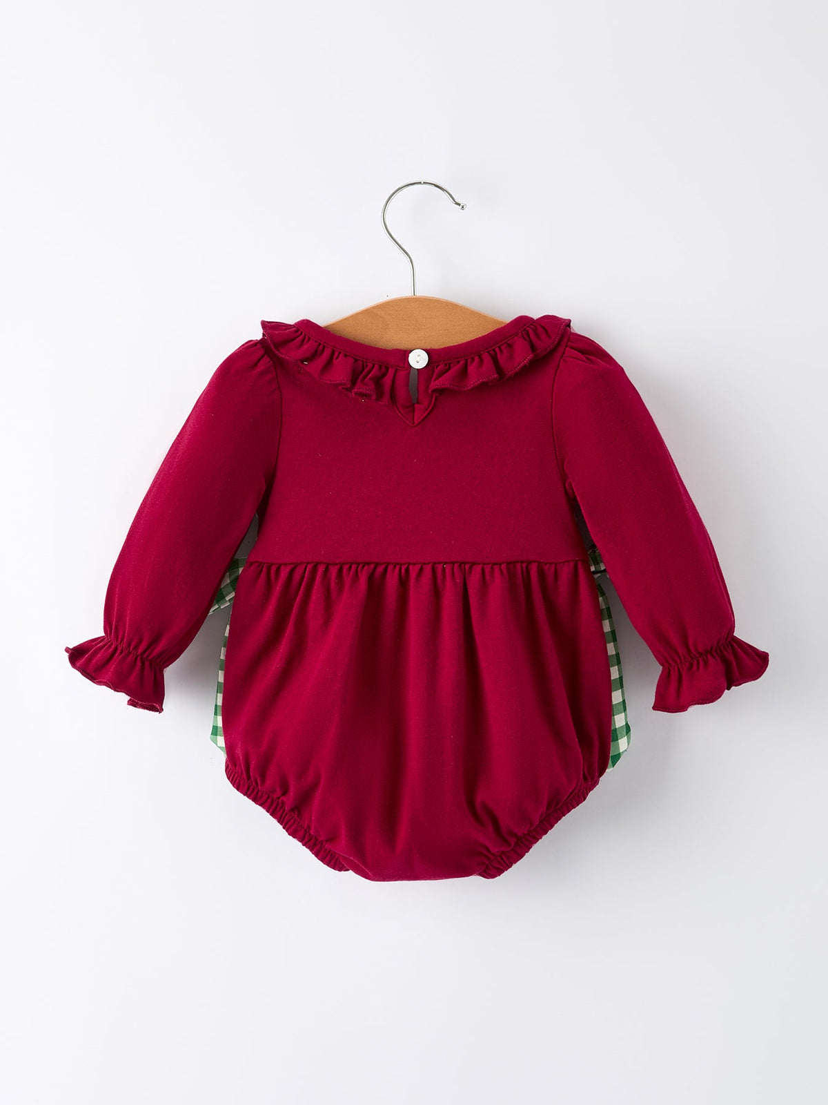 Back of red baby girl romper with ruffled collar and green plaid lining, featuring festive holiday embroidery and a bow.