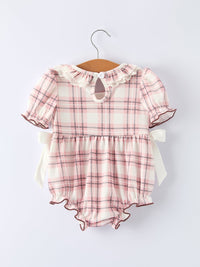 Pink plaid baby girl romper with ruffled collar, puff sleeves, side bows, and smocked bodice featuring western ranch style details.