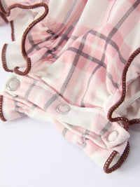 Pink plaid baby romper with smocked bodice, brown trim, and silver snap buttons. Western cowgirl style onesie.
