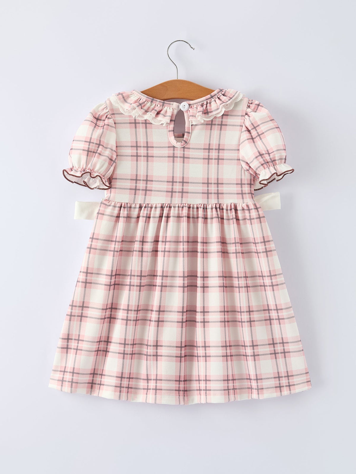 Pink plaid girls dress with ruffled collar, puff sleeves, and keyhole back detail on hanger.