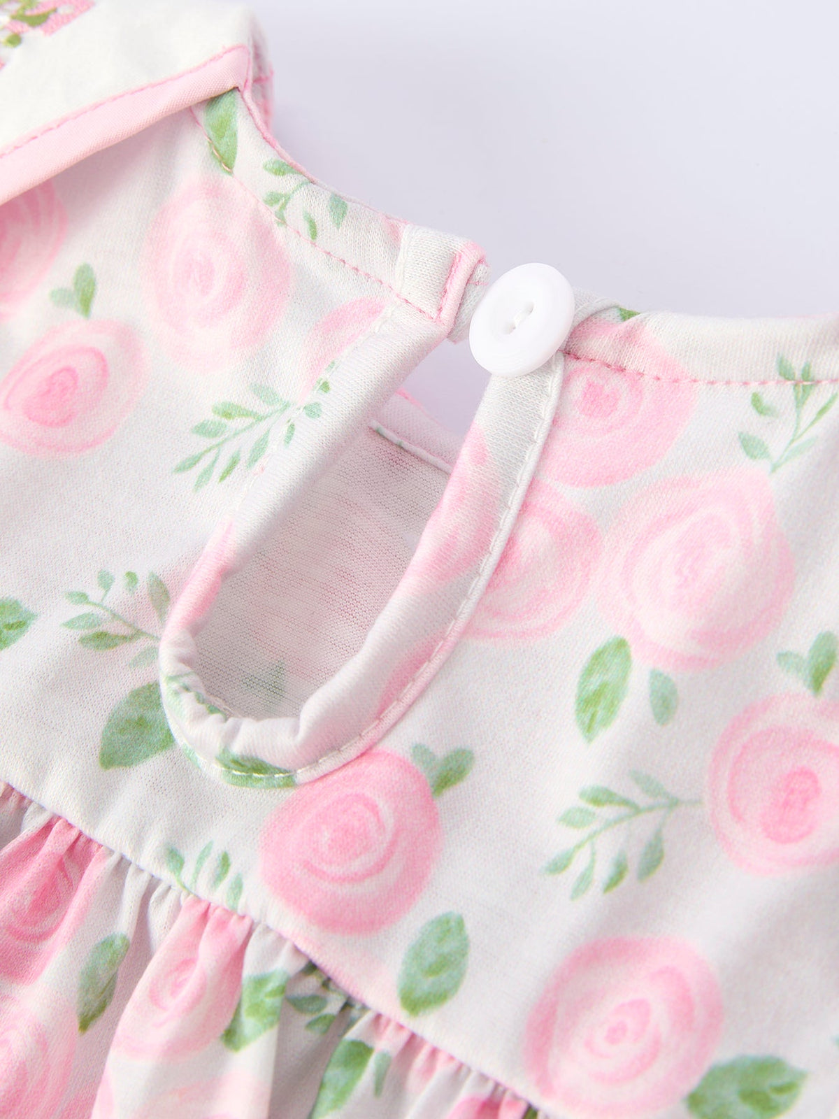 Pink floral baby bloomer set with gathered skirt and shoulder button detail.