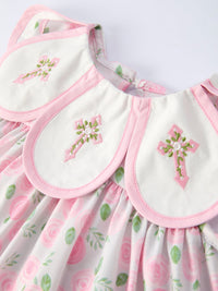 Floral smocked dress with pink Petal Peter Pan collar and pink trim on white fabric.