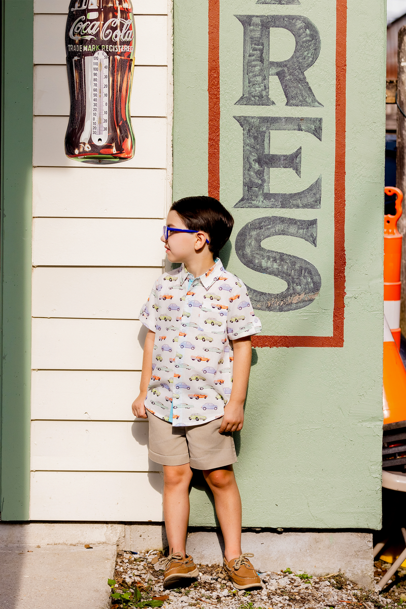 Vintage Road Trip short sleeve collared shirt with colorful vintage car print, worn by a boy; organic cotton.