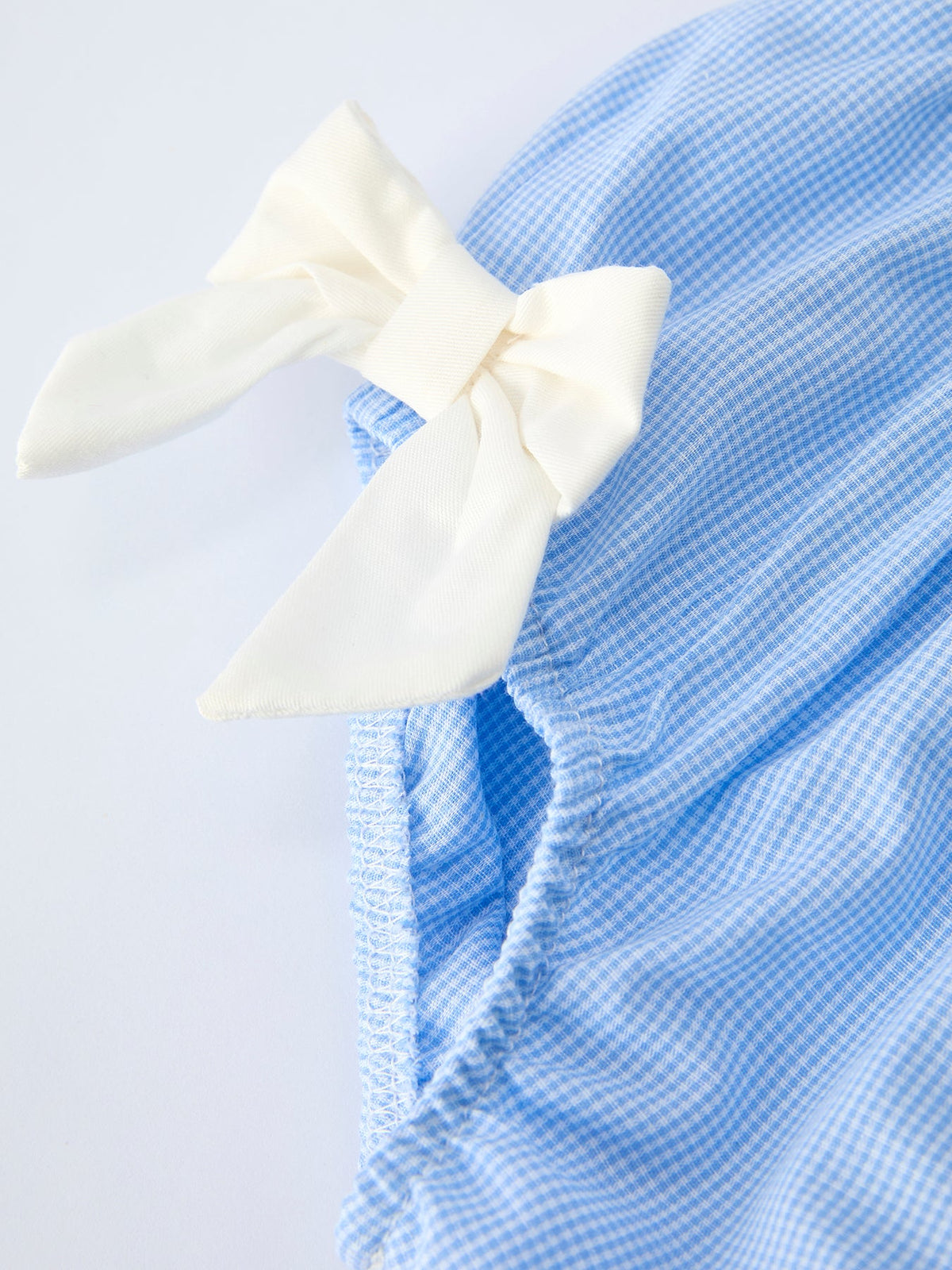 Blue gingham bloomer set for baby girls with white bow, Peter Pan collar and embroidered crosses.