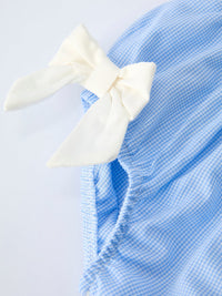 Blue gingham bloomer set for baby girls with white bow, Peter Pan collar and embroidered crosses.