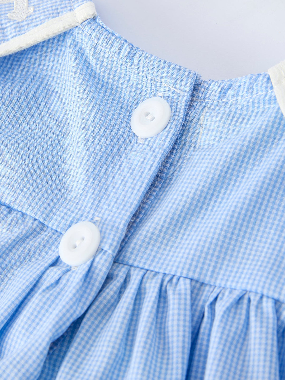 Blue gingham baby bloomer set with embroidered crosses, hand-smocked detailing, two white buttons