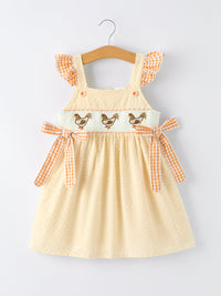 Farm Girl Chicken Smocked Bow Ruffle Dress with chicken motifs, orange gingham ruffle sleeves, and side bows.