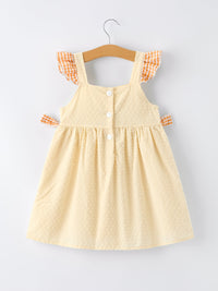 Cream Swiss-dot sundress with orange gingham ruffle straps and side bows, button-front on hanger.