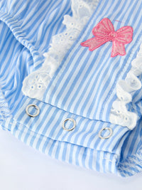 Blue striped romper fabric with pink embroidered bow and white lace trim.
