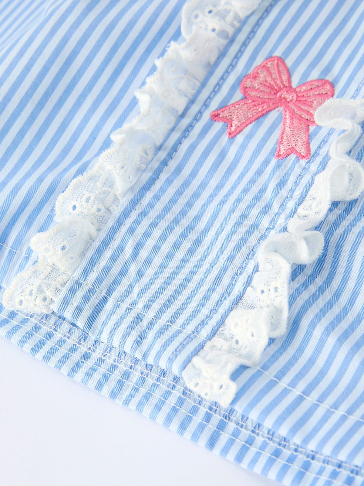 Blue striped dress with pink embroidered bow and white lace trim