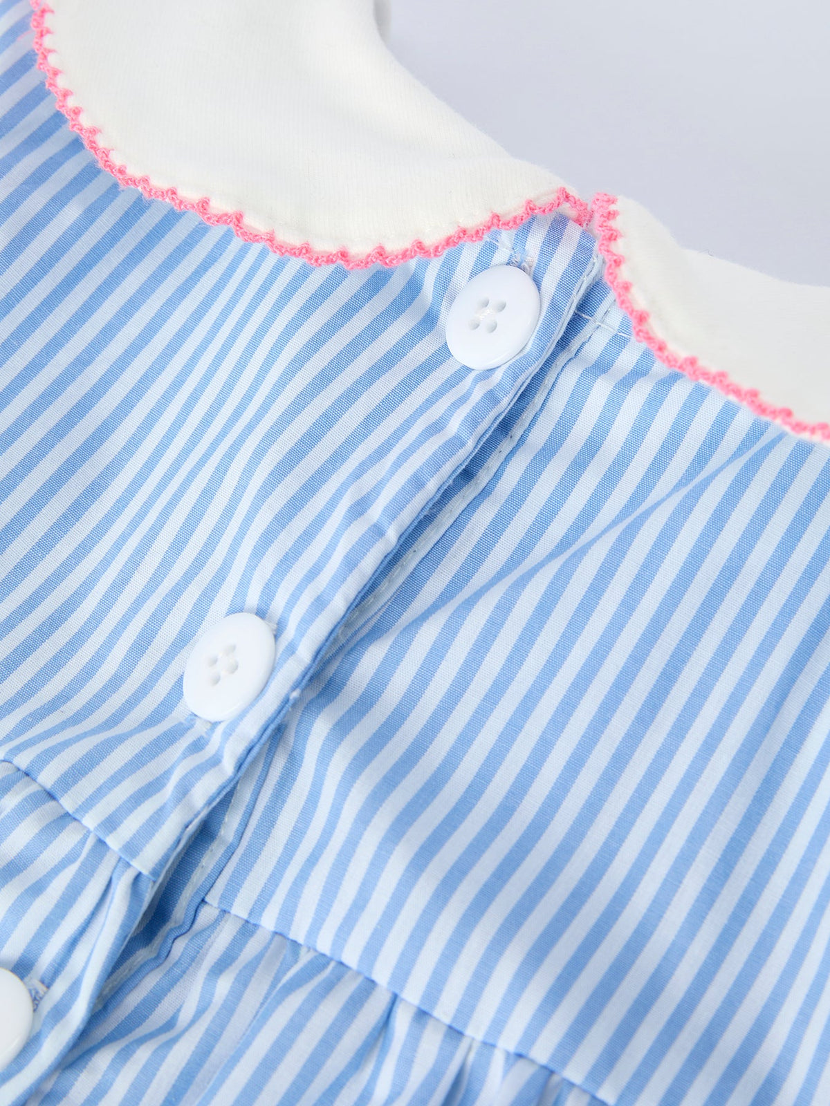 Blue striped dress with white petal Peter Pan collar, pink edge trim, and white buttons.