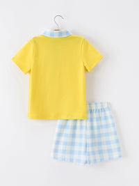 Yellow short-sleeve polo with blue gingham collar and matching blue plaid shorts for boys.