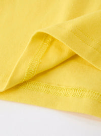 Close-up of yellow polo fabric with visible stitching and folded hem.