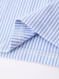 Close-up of pale blue and white striped fabric with a stitched hem from a polo set.
