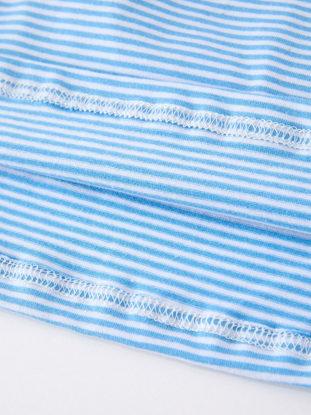 Close-up of the fabric detail from the Girls Back To School Pencil Dress with blue and white striped pattern, showcasing the soft, comfortable texture ideal for young fashionistas.