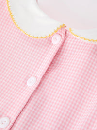 Detail shot of the collar and button closure on the Girls Back To School Pencil Twirl Dress, featuring a classic white collar and pink checkered fabric.