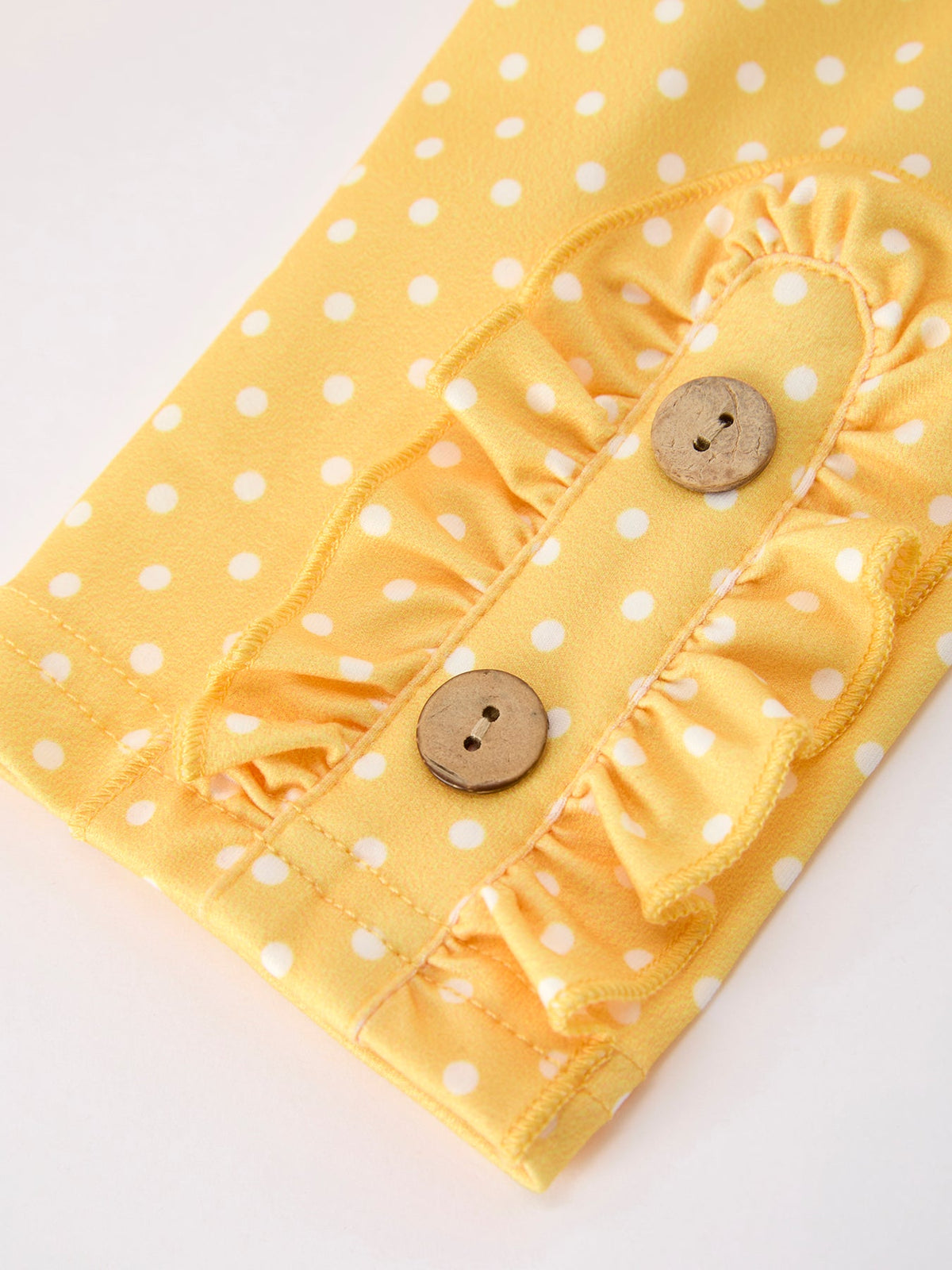 Close-up detail of the leggings from the Girls Back To School Rainbow School Bus Ruffle Dress Leggings Set, highlighting the polka-dot pattern and decorative buttons.