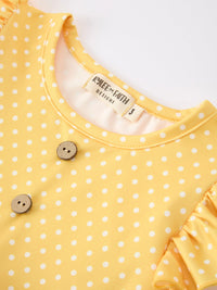 Close-up of the neckline from the Girls Back To School Rainbow School Bus Ruffle Dress Leggings Set, featuring a soft yellow fabric with polka dots and wooden buttons.