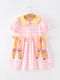 Pink plaid twirl dress for girls with yellow polka-dot bow-petal collar and pencil-shaped straps.