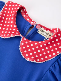 Blue dress with a red polka-dot scalloped collar and white trim.