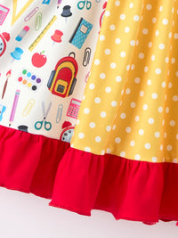 Girls back-to-school pencil patchwork twirl dress with yellow polka-dot panel and red ruffle hem.