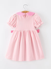 Back view of pink striped dress with petals collar and puff sleeves on a hanger