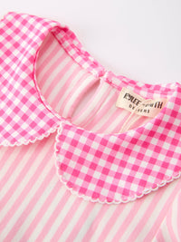Close-up of pink plaid petals collar with scalloped white trim on a pink striped dress.