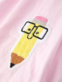 Child wearing the Girls Back To School Dress with pink pencil applique and ruffle collar, ideal for stylish school events.
