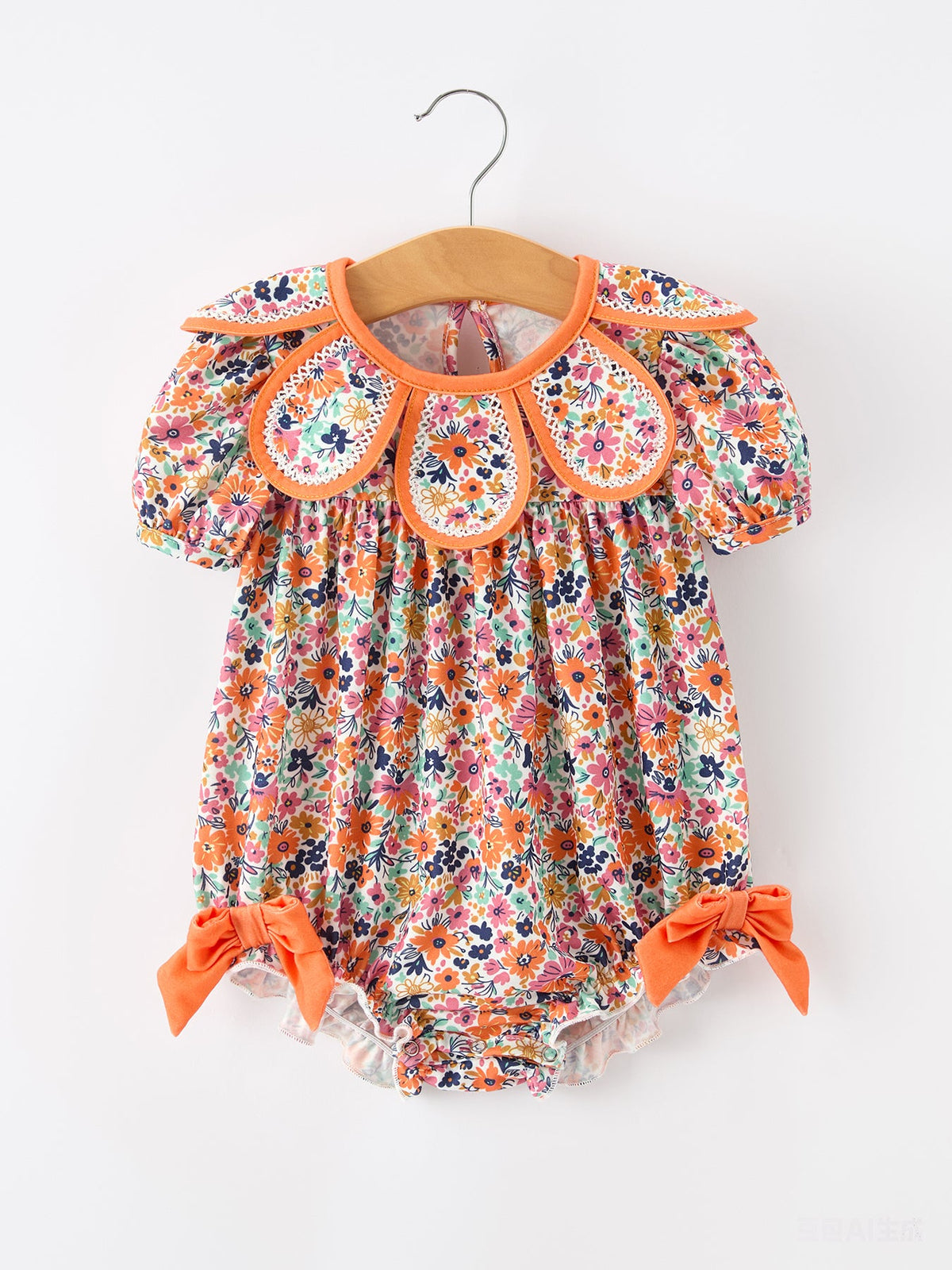 Girls romper in orange floral print with petals collar, contrast trim and eyelet detailing.
