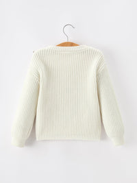 White knit sweater on a hanger against a white background
