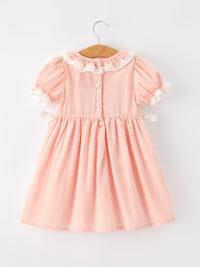 Pink girls dress with lace Peter Pan collar, puff sleeves, back buttons, and Western horse embroidery on smocked bodice.