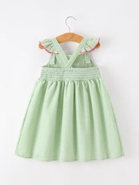 Green and white striped girls dress with cross-back straps, smocked waist, pink-trim ruffle sleeves on hanger.